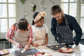 chef cooking pizza together with children