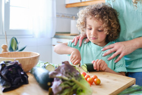 latin-boy-cuts-cucumber-slices-with-knife-kitchen-supervision-his-mother_0