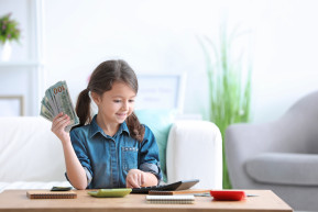 little-girl-counting-money-table-indoors